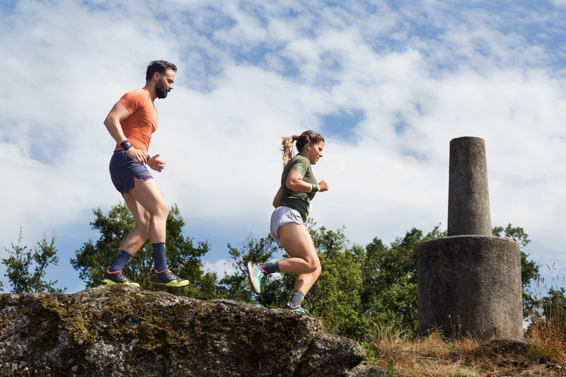 Man and woman running with their seamless workout clothes.