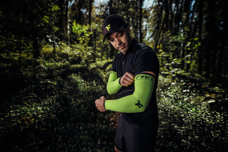 Man in the forest pulling on his Fyke compression sleeve for muscle recovery..