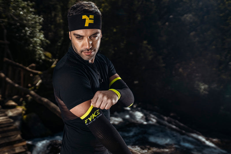 Man adjusting the black and yellow Fyke compression sleeve on his arm