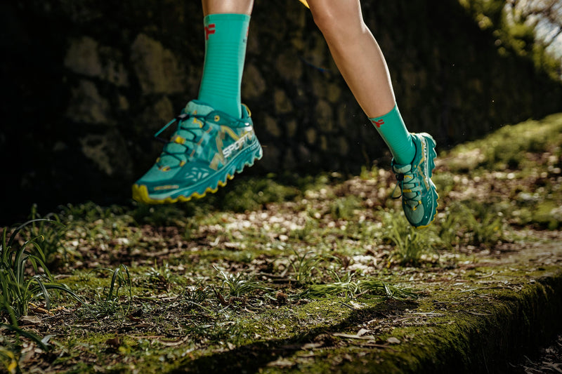 Woman legs running on a trail with Fyke socks.