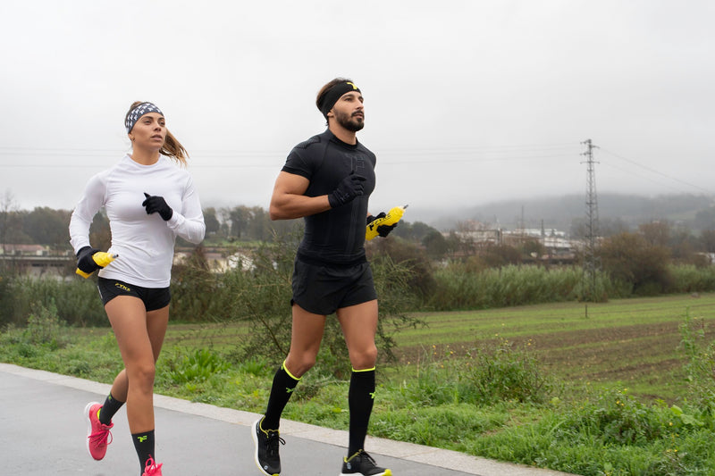Couple in running gear running on road with an agricultural background.