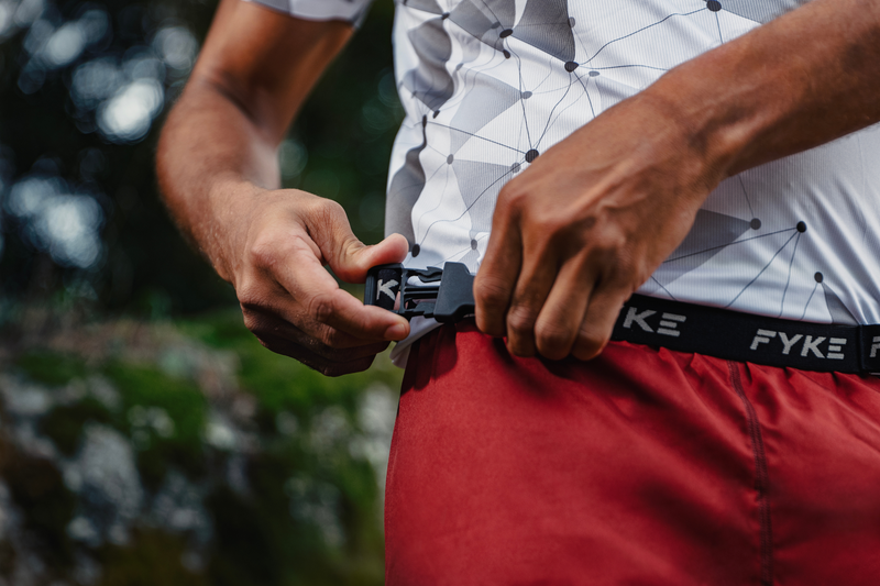 Man tightening his Fyke race belt.