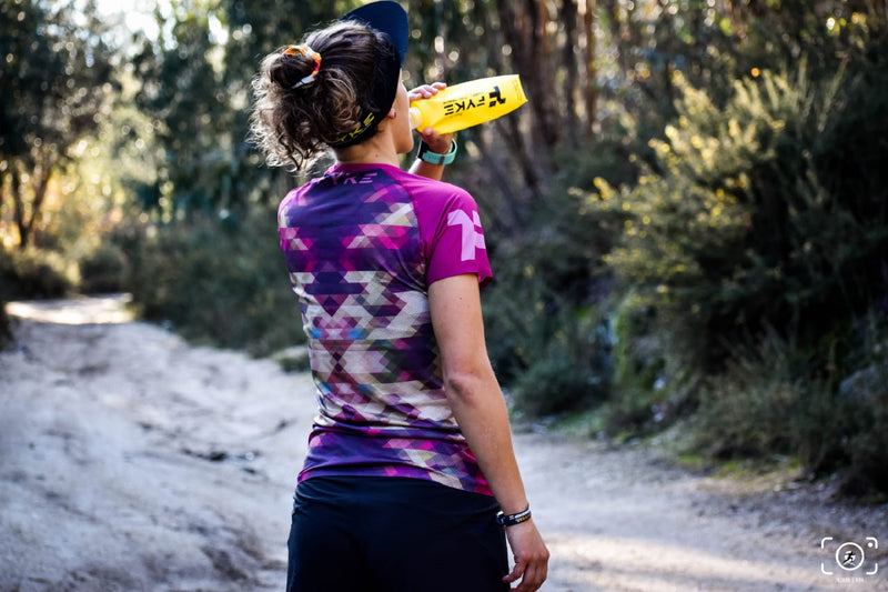 woman drinking from a soft flask