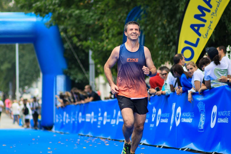 Man running a marathon in a sleeveless Fyke shirt.